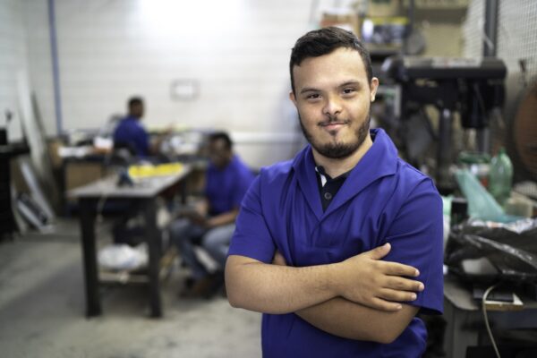 Portrait Of Smiling Special Needs Employee In Industry